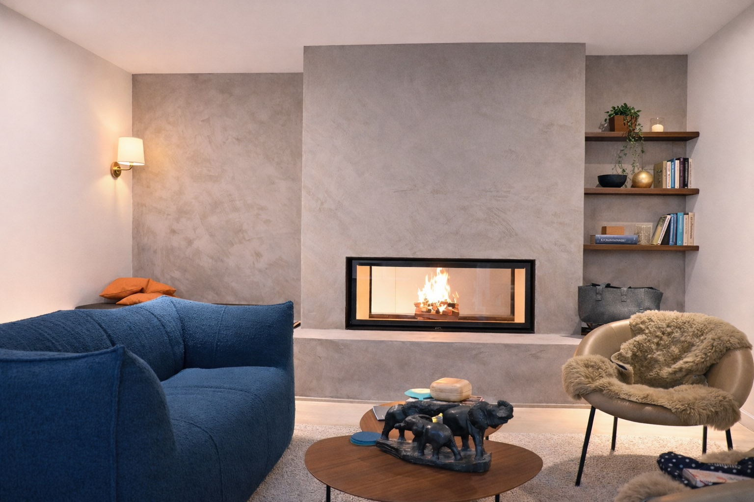 Brennender edler Kamin eingebaut in einer grauen Wand in einem schön eingerichteten Wohnzimmer